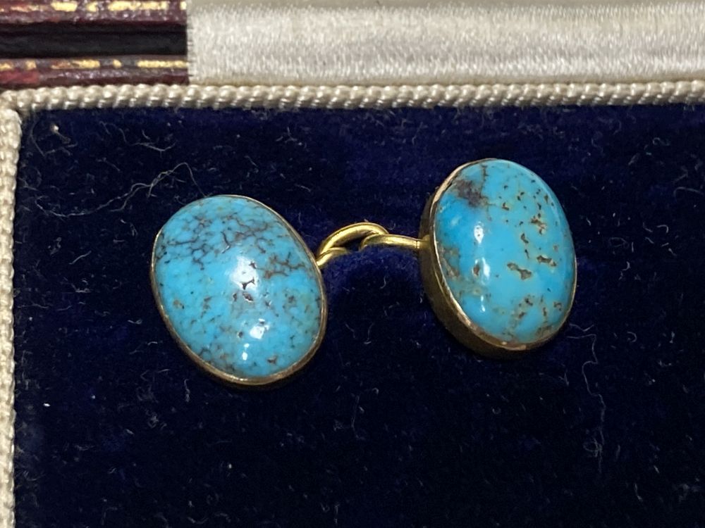 A pair of yellow metal and oval turquoise cabochon set cufflinks, stone length approx. 12mm, gross 6.1 grams,